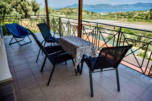 Una mesa y sillas en un balcón con vista. en Runway Mansion, stunning views and lots of space, en Skiathos