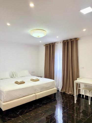 a bedroom with a white bed and a chandelier at SL Marbella in Marbella