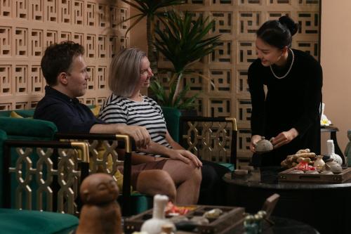 a group of people sitting in a living room with toys at GM Premium Hotel in Hanoi