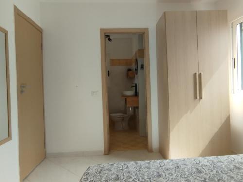 a bedroom with a bed and a bathroom with a toilet at Kite Sal in Santa Maria