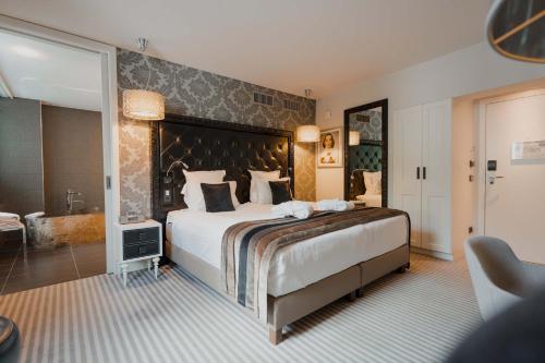 a large bedroom with a large bed and a bathroom at Le Clervaux Boutique Hotel & Spa in Clervaux