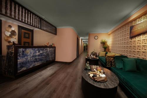 a living room with a green couch and a table at GM Premium Hotel in Hanoi