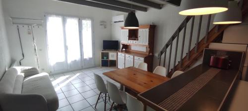 un salon avec une table et des chaises en bois dans l'établissement Gites Vert à la mer climatisation dans toutes les pièces, à Port-la-Nouvelle