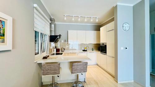 a kitchen with white cabinets and a large island at Melodia del Mare in Kotor