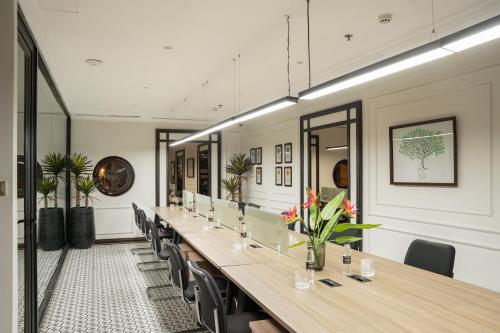 a long table in a room with chairs and mirrors at GM Premium Hotel in Hanoi