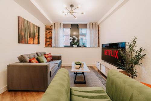 a living room with a couch and a tv at Luxury Two Bedroom Birmingham City Centre Apartment in Birmingham