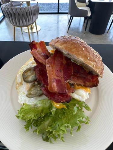 a breakfast sandwich with bacon and lettuce on a plate at My Paradise Chiang Rai in Ban Doi Hang