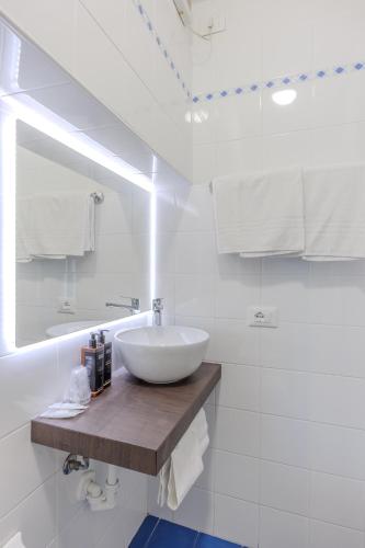 a white bathroom with a sink and a mirror at Hotel Degli Oleandri in Sirmione