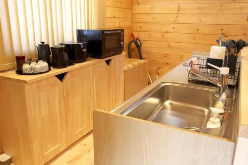 a kitchen with a sink and a microwave at Starry sky 花水木莊 in Hakone