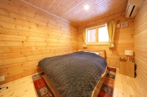 a bedroom with a bed in a wooden room at Starry sky 花水木莊 in Hakone