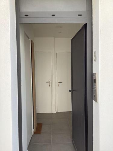 un couloir vide avec deux portes dans un bâtiment dans l'établissement AU BORD de MER AU COEUR DE LA STATION bon emplacement joli duplex contemporain tout equipe 50m2, à Bénodet