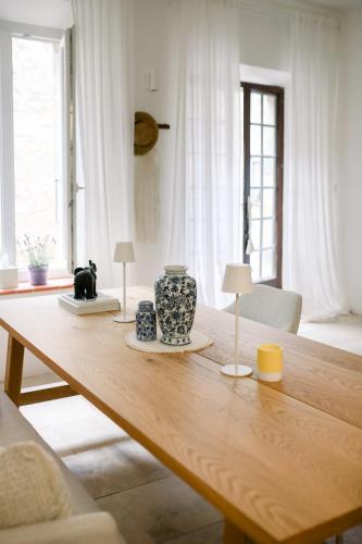 une table en bois avec deux vases au-dessus dans l'établissement Steinhaus mit Dachterrasse und Badefluss, à Ribaute