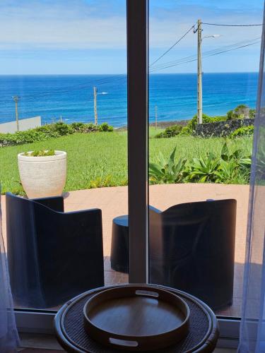 a table and chairs with a view of the ocean at Brisa do Mar in Faja Grande