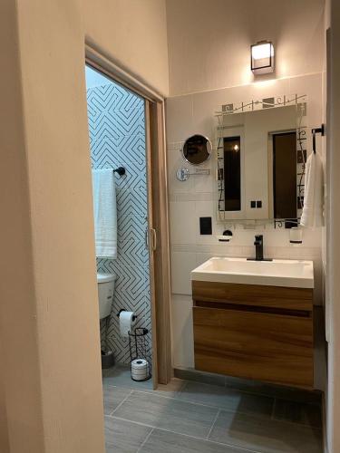 a bathroom with a sink and a toilet and a mirror at LA HIDALGO Departamento 2 in Chapala