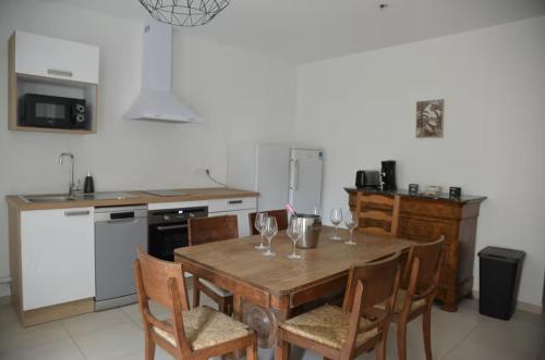 - une cuisine avec une table en bois et des verres à vin dans l'établissement Le Châtillon Central - Calme, à Châtillon-sur-Chalaronne