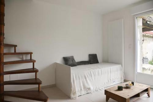 une chambre blanche avec un lit et une table dans l'établissement Le Châtillon Central - Calme, à Châtillon-sur-Chalaronne
