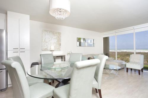 a dining room with a glass table and white chairs at Sea Vista in South Padre Island