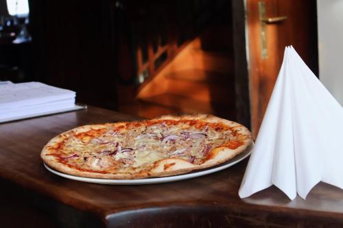 a pizza sitting on a table next to a napkin at Romantik Hotel Schwanefeld & Spa in Meerane