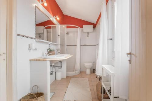 San PriamoにあるVilla La Scuderia I Unique Beachfront Villaの洗面台とトイレを備えた白いバスルーム