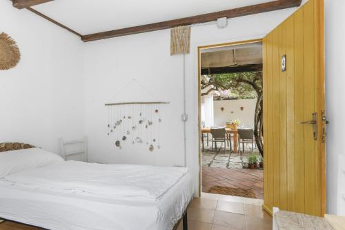 San PriamoにあるVilla La Scuderia I Unique Beachfront Villaのベッドルーム1室(ベッド1台付)、パティオ(テーブル付)