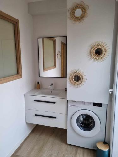 une salle de bain avec une machine à laver et un lavabo dans l'établissement Maison St Aygulf entre mer et détente, à Fréjus
