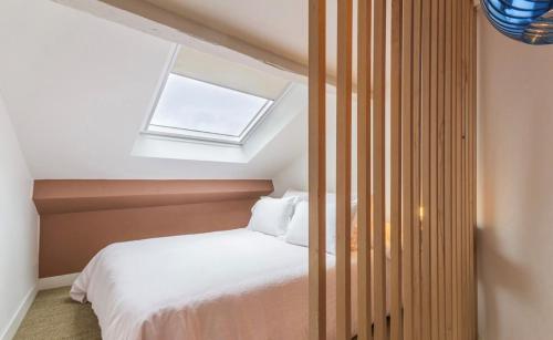 une chambre avec un lit blanc et une fenêtre dans l'établissement La Petite Maison de Giverny - Privatisation Gîte de charme 5 étoiles au cœur du village - Maison 3 Chambres, à Giverny