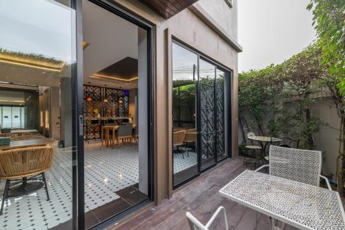 an outdoor patio with glass doors and a table and chairs at Antiya Hotel Phuket in Phuket Town