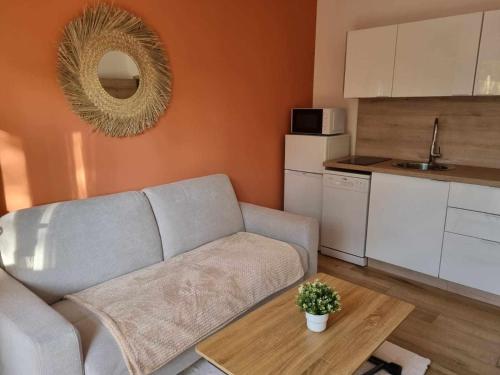 a living room with a couch and a table at Maison St Aygulf entre mer et détente in Fréjus