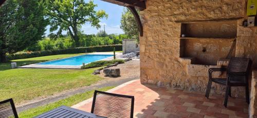 un patio avec des chaises et une piscine dans l'établissement Douceur de Vivre Évasion Familiale au Vert, à Beaumont-du-Périgord