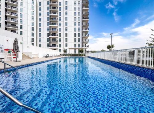 a large swimming pool in front of a building at Luxury 4 Bedroom Apartment with Ferrari World and Sea Views, Yas Island Waterfront, Pool, Gym, Playground, Walk to Yas Mall in Abu Dhabi