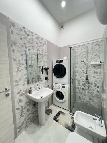 a bathroom with a washing machine and a sink at Palazzo Oberdan in Afragola