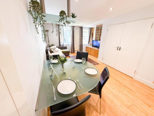 a dining room with a glass table and chairs at Spacious Detached Houses with FREE PARKING near Little Venice, Paddington & Hyde Park by Staylio London in London