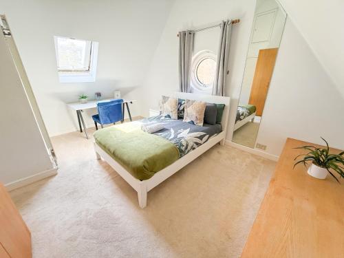 a bedroom with a bed and a table and a mirror at Spacious Detached Houses with FREE PARKING near Little Venice, Paddington & Hyde Park by Staylio London in London