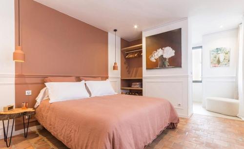 a bedroom with a bed and a vase of flowers at La Petite Maison de Giverny - Chambres privées - Gîte 5 étoiles au Cœur du village in Giverny