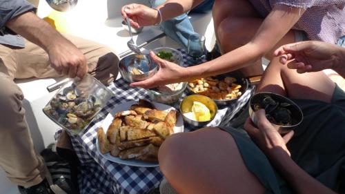 a group of people sitting around a table with food at Racing Boat in Lisbon