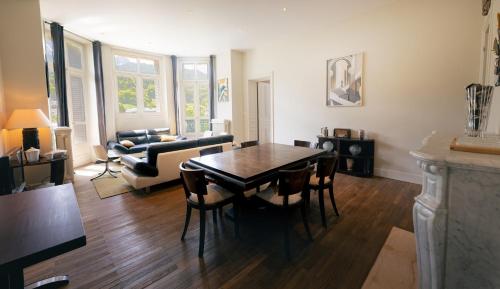 un salon avec une table, des chaises et un canapé dans l'établissement Appartement 130m2 dans villa Mexicaine, à Barcelonnette