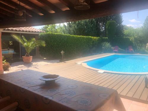 un patio avec une table et une piscine dans l'établissement Un îlot tropical en Cévennes, à Saint-Privat-des-Vieux