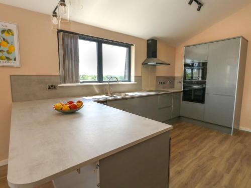 a kitchen with a bowl of fruit on a counter at Frogwell in Sherborne