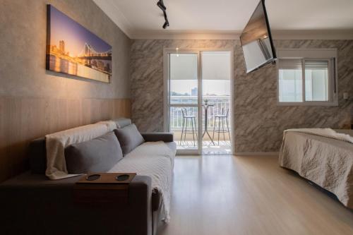 a living room with a couch and a balcony at 0610 - Studio alto padrão in Guarulhos