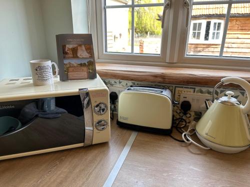 a microwave oven sitting on the floor next to a window at The Stables & Silos in Braintree