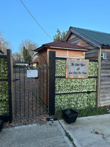 a building with a fence with a sign on it at The Stables & Silos in Braintree