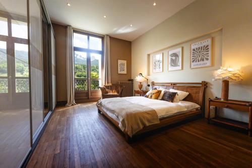 une chambre avec un grand lit et une grande fenêtre dans l'établissement Appartement 130m2 dans villa Mexicaine, à Barcelonnette