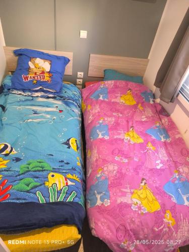 deux lits côte à côte dans une chambre dans l'établissement Mobil home Le castellas, à Sète