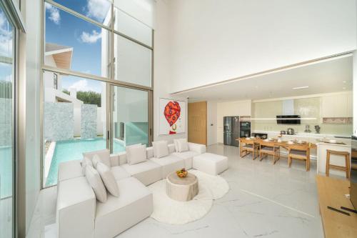 a living room with a white couch and a table at 4BR Private Pool Villa near Laguna & Beach - Lux Pride 2 by Warm Plus in Ban Pak Lak