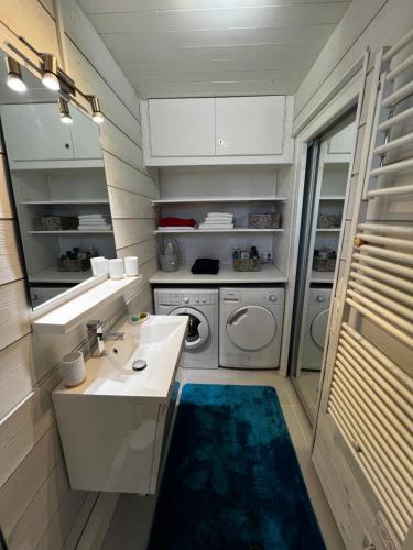 une salle de bain avec un lavabo et une machine à laver dans l'établissement Appartement cosy avec vue exceptionnelle, à Saint-Gervais-les-Bains
