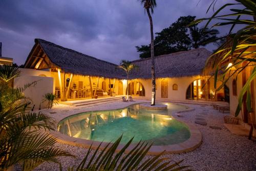 a house with a swimming pool at night at Villa Keluarga in Gili Air