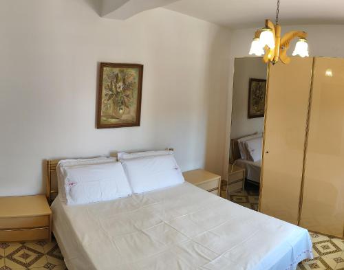 ein Schlafzimmer mit einem weißen Bett und einem Spiegel in der Unterkunft Appartamento Marechiaro in Scalea