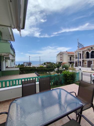 a patio with a glass table and chairs on a balcony at Nikiti Blue Horizon in Nikiti