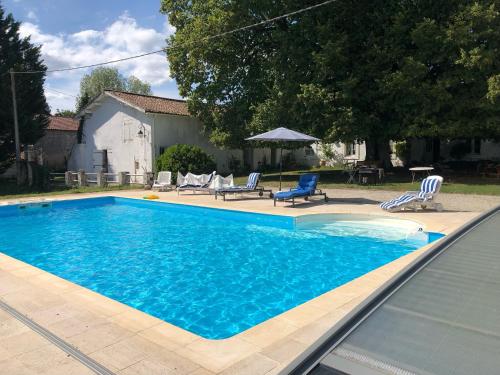 una piscina azul con 2 sillas y una mesa en La maison de Léandre - Medoc, en Saint-Seurin-de-Cadourne