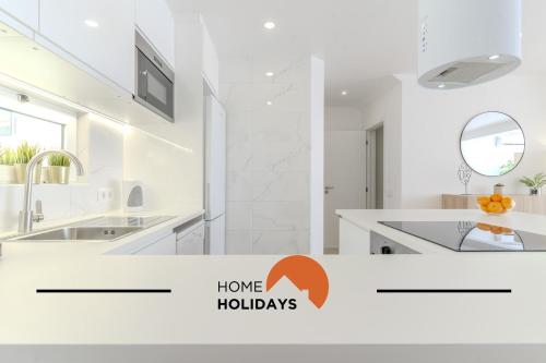 a white kitchen with a sink and a mirror at #171 Páteo 2 Flat by Home Holidays in Albufeira
